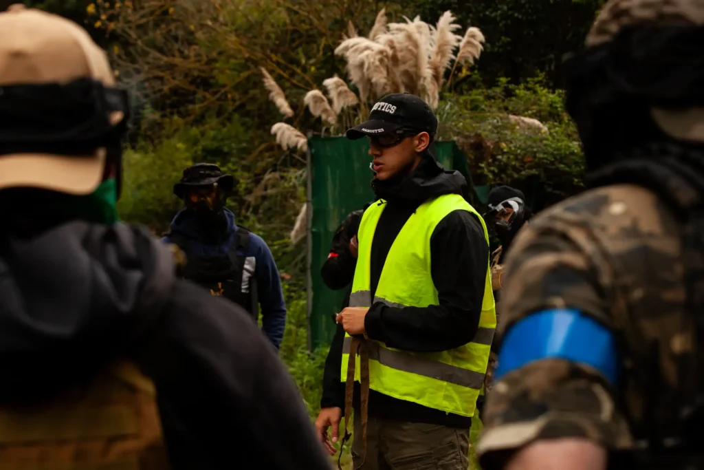 El silencio del briefing concentra la tensión. La estrategia nace justo antes de la acción.